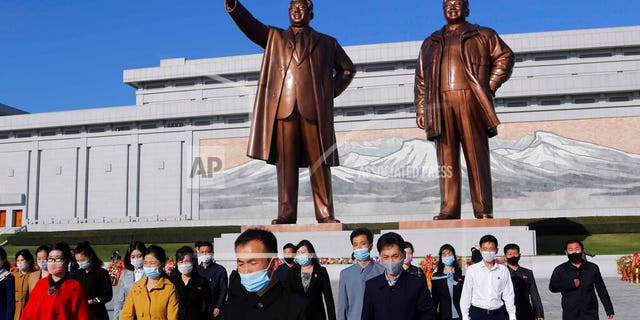 People visit the Mansu Hill to lay flowers to the bronze statues of former North Korean leaders Kim Il Sung and Kim Jong Il in Pyongyang, North Korea, Saturday, Oct. 10, 2020, on the occasion of the 75th founding anniversary of the country's Workers' Party. (AP Photo/Cha Song Ho)
