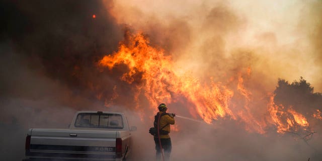 Firefighter Raymond Vasquez battles the Silverado Fire Monday, Oct. 26, 2020, in Irvine, Calif. 