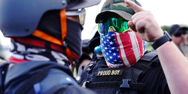FILE - In this Sept. 26, 2020 file photo, a right-wing demonstrator gestures toward a counter protester as members of the Proud Boys and other right-wing demonstrators rally in Portland, Ore. (AP Photo/John Locher, File)