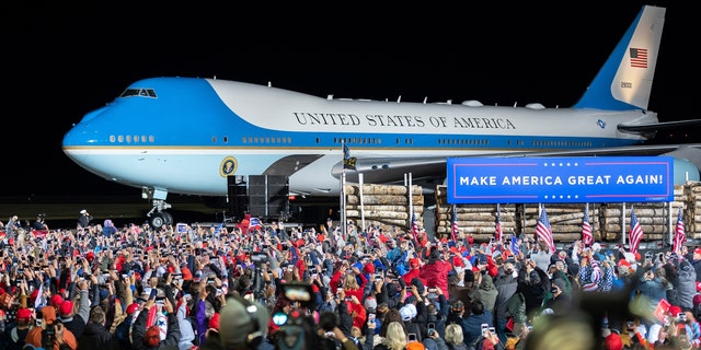 A crowd cheers as Air Force One arrives with President Donald Trump at Duluth, Minn., International Airport on Wednesday, Sept. 30, 2020. (AP Photo/Jack Rendulich)