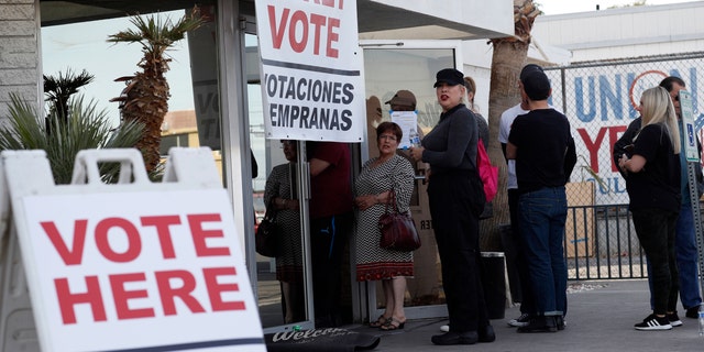 In this Feb. 15, 2020 file photo, people wait in line at an early voting location at the culinary workers union hall in Las Vegas. (AP Photo/John Locher, File)