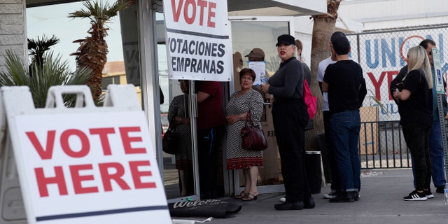 In this Feb. 15, 2020 file photo, people wait in line at an early voting location at the culinary workers union hall in Las Vegas. (AP Photo/John Locher, File)