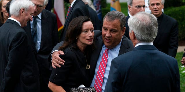 In this Saturday, Sept. 26, 2020, photo former New Jersey Gov. Chris Christie, front second from right, speaks with others after SCOTUS nomination. Notre Dame President Father John Jenkins stands at back right. (AP Photo/Alex Brandon)