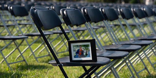 A photograph of Leo Villanueva who lost his life due the COVID-19, sits in one of the thousands of empty chairs, who represent a fraction of the more than 200,000 lives lost due the COVID-19 are seen during the National COVID-19 Remembrance, at The Ellipse outside of the White House, Sunday, Oct. 4, 2020, in Washington. (AP Photo/Jose Luis Magana)