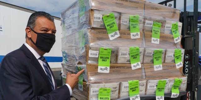 California Secretary of State Alex Padilla stands next to a pallet with voting ballots, after a news conference on Orange County's comprehensive plans to safeguard election and provide transparency in Santa Ana, Calif., Monday, Oct. 5, 2020. The Registrar of Voters for Orange County, Calif., is the fifth largest voting jurisdiction in the United States, serving more than 1.6 million registered voters. (AP Photo/Damian Dovarganes)