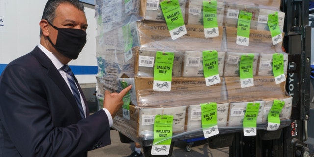 California Secretary of State Alex Padilla stands next to a pallet with voting ballots, after a news conference on Orange County's comprehensive plans to safeguard election and provide transparency in Santa Ana, Calif., Monday, Oct. 5, 2020. The Registrar of Voters for Orange County, Calif., is the fifth largest voting jurisdiction in the United States, serving more than 1.6 million registered voters. (AP Photo/Damian Dovarganes)