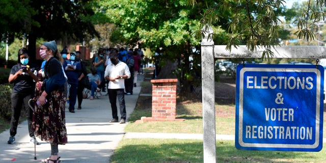 Voters wait in line outside the Richland County election office on the first day of in-person absentee voting in South Carolina on Monday, Oct. 5, 2020, in Columbia, S.C. A number of counties have polling places where people can vote almost like they would in person on Election Day, instead of having to mail in their absentee ballot. (AP Photo/Meg Kinnard)