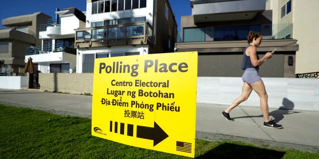 FILE: A woman runs on a path by a polling place during primary elections in San Diego. 