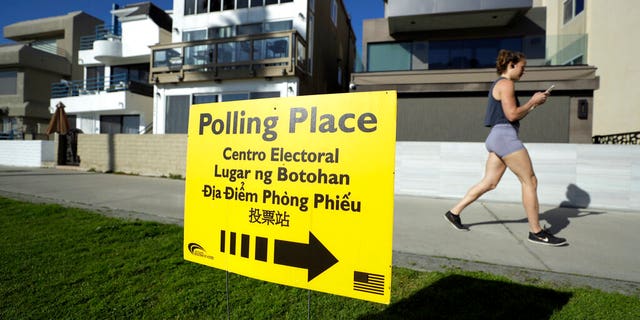 FILE: A woman runs on a path by a polling place during primary elections in San Diego.