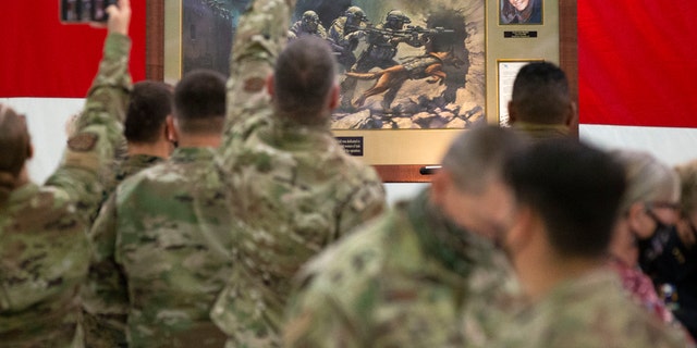 Members of the Air National Guard view the painting honoring Kayla Mueller, a humanitarian and Prescott native, during a ceremony at the Goldwater Air National Guard Base, Oct. 8, in Phoenix. (Rob Schumacher/The Arizona Republic via AP)