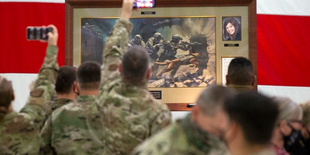 Members of the Air National Guard view the painting honoring Kayla Mueller, a humanitarian and Prescott native, during a ceremony at the Goldwater Air National Guard Base, Oct. 8, in Phoenix. (Rob Schumacher/The Arizona Republic via AP)