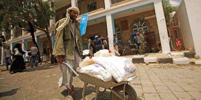 FILE: A displaced Yemeni receives food aid provided by the World Food Program, at a school in Sanaa, Yemen.