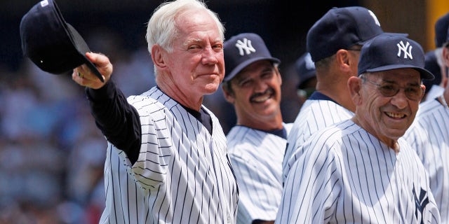 In this July 7, 2007 file photo, former New York Yankees pitcher Whitey Ford, left, acknowledges the crowd during introductions as Yogi Berra, right looks on before the Old Timer's game at Yankee Stadium in New York. A family member tells The Associated Press on Friday, Oct. 9, 2020, that Ford died at his Long Island home Thursday night. (AP Photo/Julie Jacobson, File)