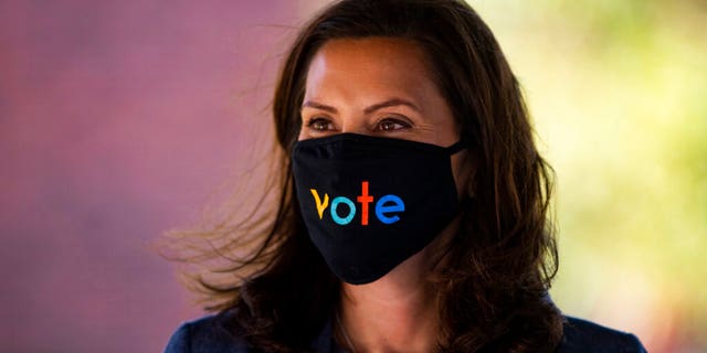 Michigan Gov. Gretchen Whitmer wears a mask with the word "vote" displayed on the front during a roundtable discussion on healthcare in Kalamazoo, Mich. 