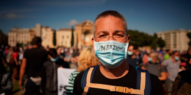 A woman wears a mask reading in Italian Liberazione (Liberation) as people gather to protest against the government restriction measures to curb the spread of COVID-19, in Rome, Saturday, Oct. 10, 2020. (AP Photo/Andrew Medichini)
