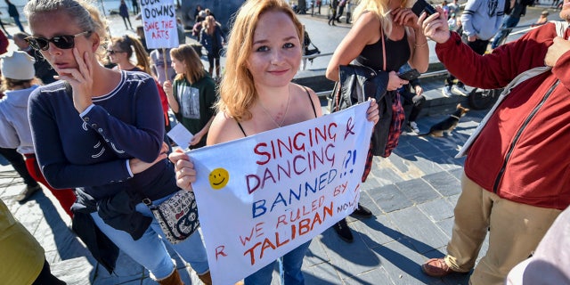 A woman holds a banner during an anti-lockdown protest outside the Senedd Cymru in Cardiff Bay, Wales, Sunday, Oct. 11, 2020. So far the U.K. has experienced Europe’s deadliest virus outbreak, with over 42,750 confirmed deaths. (Ben Birchall/PA via AP)