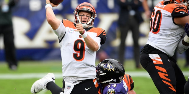 Baltimore Ravens linebacker Tyus Bowser, back, makes a hit on Cincinnati Bengals quarterback Joe Burrow as he tries a pass during the first half of an NFL football game, Sunday, Oct. 11, 2020, in Baltimore. (AP Photo/Nick Wass)