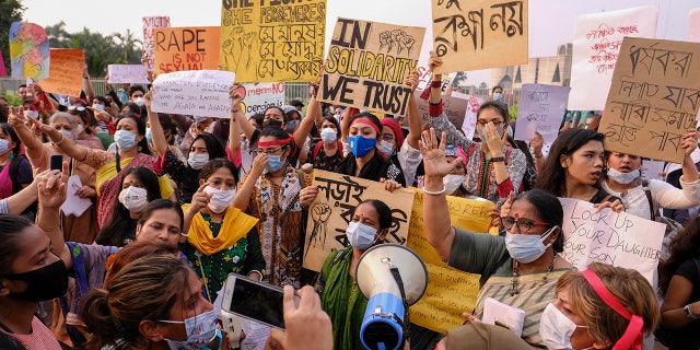 Women’s rights activists and others protesting against gender-based violence hold placards outside the Parliament in Dhaka, Bangladesh, Friday, Oct.9, 2020. Bangladesh's Cabinet has approved an increase in the maximum punishment in rape cases to death from life imprisonment after a series of recent sexual assaults triggered protests. (AP Photo/ Mahmud Hossain Opu)