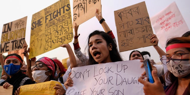 Women’s rights activists and others protesting against gender-based violence hold placards outside the Parliament in Dhaka, Bangladesh, Friday, Oct.9, 2020. Bangladesh's Cabinet has approved an increase in the maximum punishment in rape cases to death from life imprisonment after a series of recent sexual assaults triggered protests. (AP Photo/ Mahmud Hossain Opu)