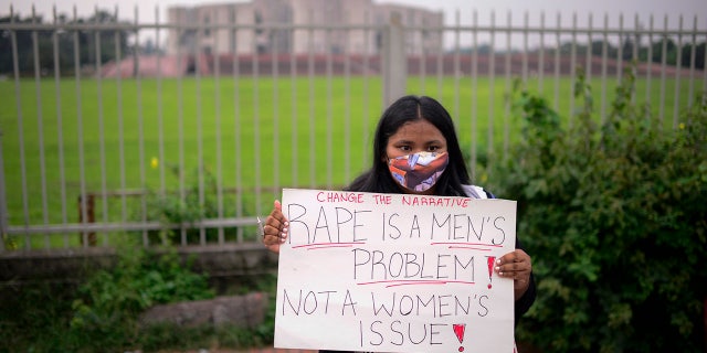 A women’s rights activist among those protesting against gender based violence holds a placard outside the Parliament in Dhaka, Bangladesh, Friday, Oct.9, 2020. Bangladesh's Cabinet has approved an increase in the maximum punishment in rape cases to death from life imprisonment after a series of recent sexual assaults triggered protests. (AP Photo/ Mahmud Hossain Opu)