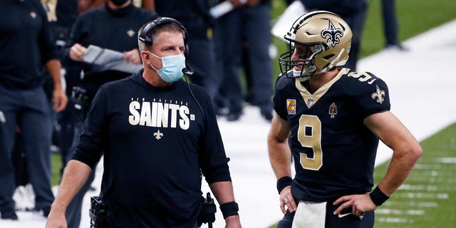 New Orleans Saints head coach Sean Payton talks with quarterback Drew Brees (9) in the first half of an NFL football game against the Los Angeles Chargers in New Orleans, Monday, Oct. 12, 2020. (AP Photo/Butch Dill)
