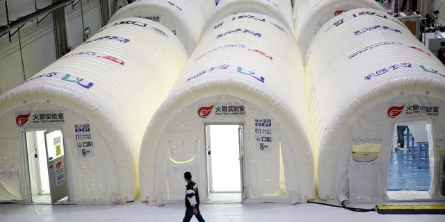 A man walks past temporary COVID-19 test processing labs set up inside inflatable tents in Qingdao in eastern China's Shandong Province, Oct. 14.  (Chinatopix via AP)
