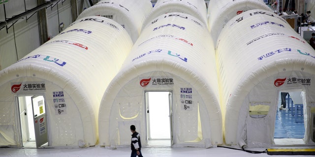 A man walks past temporary COVID-19 test processing labs set up inside inflatable tents in Qingdao in eastern China's Shandong Province, Oct. 14. (Chinatopix via AP)