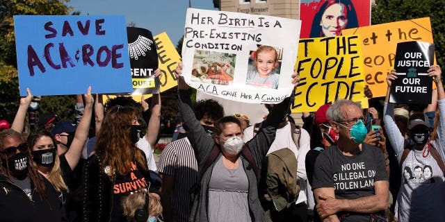 Protesters opposed to the confirmation of President Donald Trump's Supreme Court nominee Amy Coney Barrett, rally at the Supreme Court on Capitol Hill, in Washington, Wednesday, Oct. 14, 2020. (AP Photo/Jose Luis Magana)