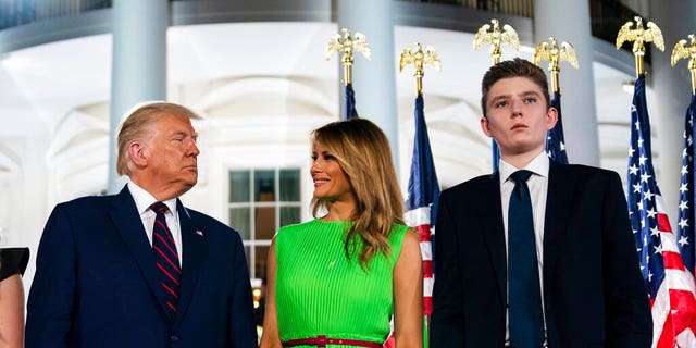 FILE: Barron Trump right, stands with President Donald Trump and first lady Melania Trump on the South Lawn of the White House on the fourth day of the Republican National Convention in Washington.