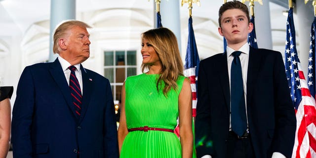 FILE: Barron Trump right, stands with President Donald Trump and first lady Melania Trump on the South Lawn of the White House on the fourth day of the Republican National Convention in Washington.