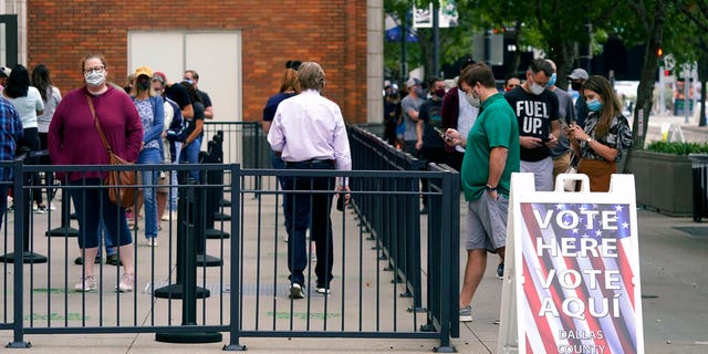 Voters line up and wait to cast a ballot at the American Airlines Center during early voting Thursday, Oct. 15, 2020, in Dallas. (AP Photo/LM Otero)