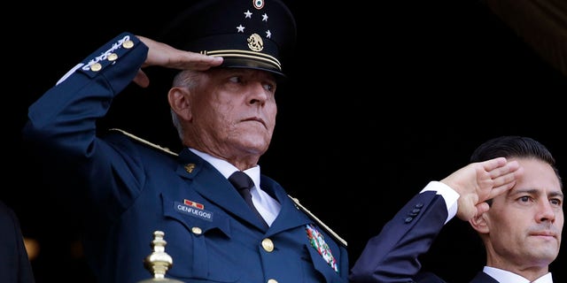 FILE - In this Sept. 16, 2016 file photo, Defense Secretary Gen. Salvador Cienfuegos, left, and Mexico's President Enrique Pena Nieto, salute during the annual Independence Day military parade in Mexico City's main square. Mexico's top diplomat says the country's former defense secretary, Gen. Salvador Cienfuegos, has been arrested in Los Angeles. Foreign Relations Secretary Marcelo Ebrard wrote Thursday, Oct. 15, 2020 in his Twitter account that U.S. Ambassador Christopher Landau had informed him of Cienfuegos' arrest. (AP Photo/Rebecca Blackwell, File)