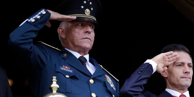 FILE - In this Sept. 16, 2016 file photo, Defense Secretary Gen. Salvador Cienfuegos, left, and Mexico's President Enrique Pena Nieto, salute during the annual Independence Day military parade in Mexico City's main square. Mexico's top diplomat says the country's former defense secretary, Gen. Salvador Cienfuegos, has been arrested in Los Angeles. Foreign Relations Secretary Marcelo Ebrard wrote Thursday, Oct. 15, 2020 in his Twitter account that U.S. Ambassador Christopher Landau had informed him of Cienfuegos' arrest. (AP Photo/Rebecca Blackwell, File)