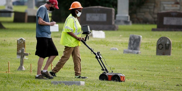 ILE - In this July 17, 2020, file photo, workers use ground penetrating radar as work continues on a search for a potential unmarked mass grave from the 1921 Tulsa Race Massacre, at Oaklawn Cemetery in Tulsa, Okla. (AP Photo/Sue Ogrocki File)
