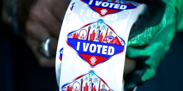 FILE: A poll worker displays "I Voted" stickers during the first day of early voting in Las Vegas.