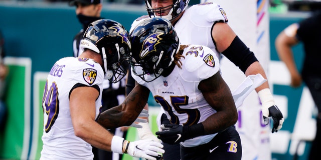 Baltimore Ravens' Gus Edwards (35) celebrates with Mark Andrews (89) after scoring a touchdown during the first half of an NFL football game against the Philadelphia Eagles, Sunday, Oct. 18, 2020, in Philadelphia. (AP Photo/Chris Szagola)