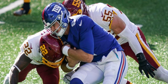 Washington Football Team's Deshazor Everett (22) and Cole Holcomb (55) tackle New York Giants quarterback Daniel Jones (8) during the second half of an NFL football game Sunday, Oct. 18, 2020, in East Rutherford, N.J. (AP Photo/John Minchillo)