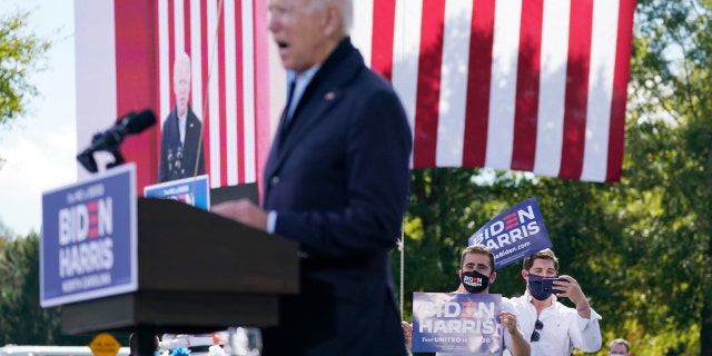Supporters hold up a signs as Democratic presidential candidate former Vice President Joe Biden speaks during a campaign event at Riverside High School in Durham, N.C., Sunday, Oct. 18, 2020. (AP Photo/Carolyn Kaster)