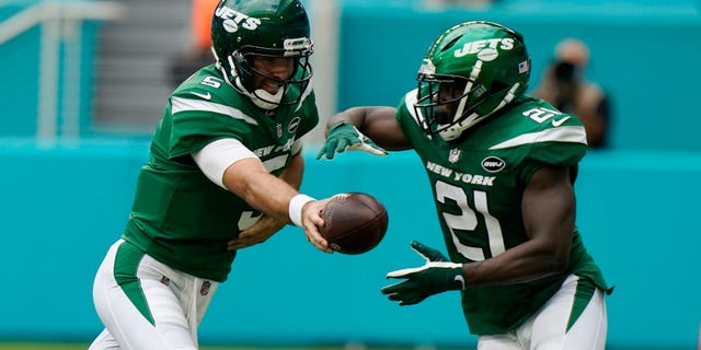 New York Jets quarterback Joe Flacco (5) hands the ball to running back Frank Gore (21), during the first half of an NFL football game against the Miami Dolphins Sunday, Okt.. 18, 2020, in Miami Gardens, Fla.