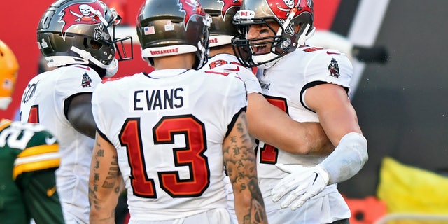 Tampa Bay Buccaneers tight end Rob Gronkowski (87) celebrates with teammates, including Mike Evans (13) after catching a touchdown pass against the Green Bay Packers during the first half of an NFL football game Sunday, Oct. 18, 2020, in Tampa, Fla. (AP Photo/Jason Behnken)