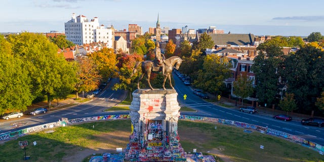 The afternoon sun illuminates the statue of Confederate General Robert E. Lee on Monument Ave in Richmond, Va., Monday, Oct. 19, 2020. (AP Photo/Steve Helber)