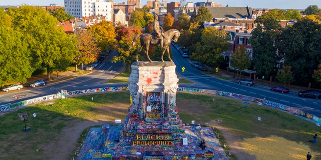 The afternoon sun illuminates the statue of Confederate General Robert E. Lee on Monument Ave in Richmond, Va., Monday, Oct. 19, 2020. (AP Photo/Steve Helber)