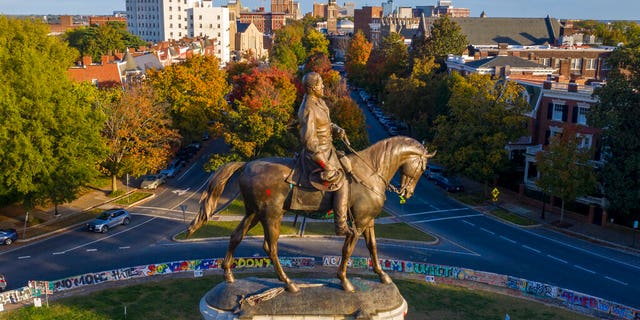 The afternoon sun illuminates the statue of Confederate General Robert E. Lee on Monument Ave in Richmond, VA, 星期一, 十月. 19, 2020. A Richmond judge heard arguments in a lawsuit over the Governors' order to remove the statue. (AP Photo/Steve Helber)