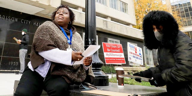 Madison, Wis. residents Theola Carter, left, and Carrie Braxton fill out their ballots on the first day of the state's in-person absentee voting window for the Nov. 3 election.