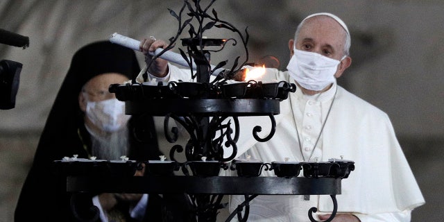 Pope Francis lights a candle for peace during an inter-religious ceremony in the square outside the City Hall of Rome, Tuesday, October 20, 2020 (AP Photo / Gregorio Borgia).