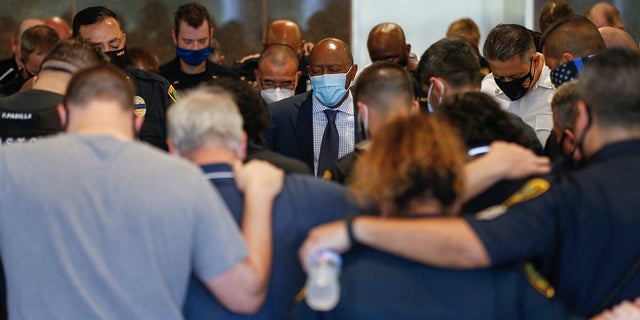 Mayor Sylvester Turner, center, prays with Houston Police officers, after learning Sgt. Harold Preston died at Memorial Hermann Hospital on Oct. 20, in Houston. Two officers were shot by a suspect during a domestic violence call at an apartment complex. (Godofredo A. Vásquez/Houston Chronicle via AP)