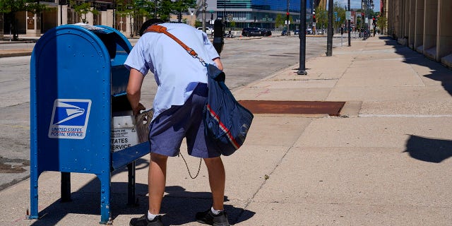 Was my vote counted? A state-by-state guide to tracking your absentee ballot 6 FILE - In this Aug. 18, 2020, file photo, a postal worker empties a box near the Fiserv Forum in Milwaukee. (AP Photo/Morry Gash, File)