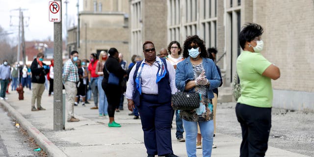 A line of voters wraps around the block outside Washington High School in Milwaukee during the primary election on April 7, 2020. 