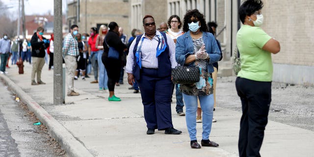 A line of voters wraps around the block outside Washington High School in Milwaukee during the primary election on April 7, 2020.