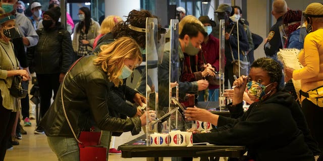 Voters sign in to cast votes at the Madison Square Garden's early voting polling site, Saturday Oct. 24, 2020, in New York.